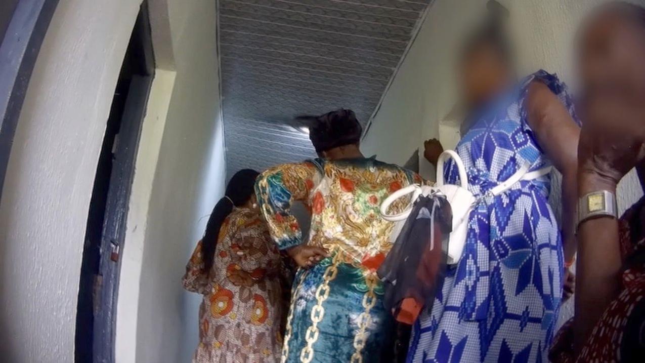 نساء يرتدين فساتين زاهية مزخرفة وهن يقفن في الممر في انتظار المقابلة