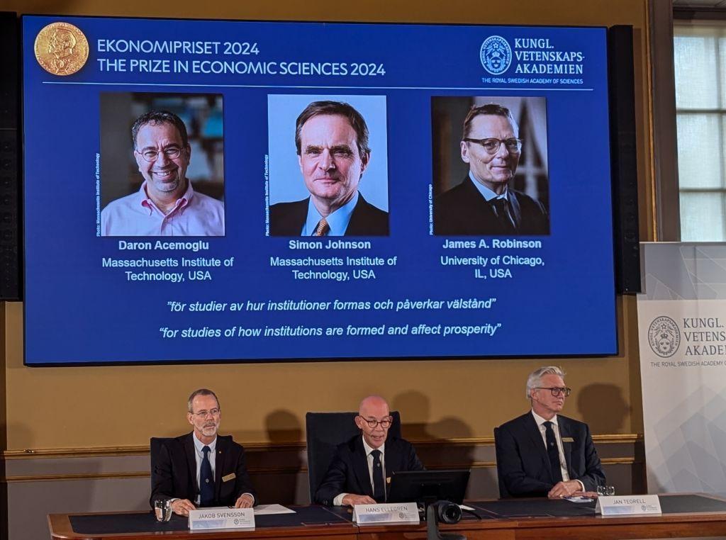 Foto da cerimônia de entrega do Prêmio Nobel a Daron Acemoglu, Simon Johnson e James A. Robinson.