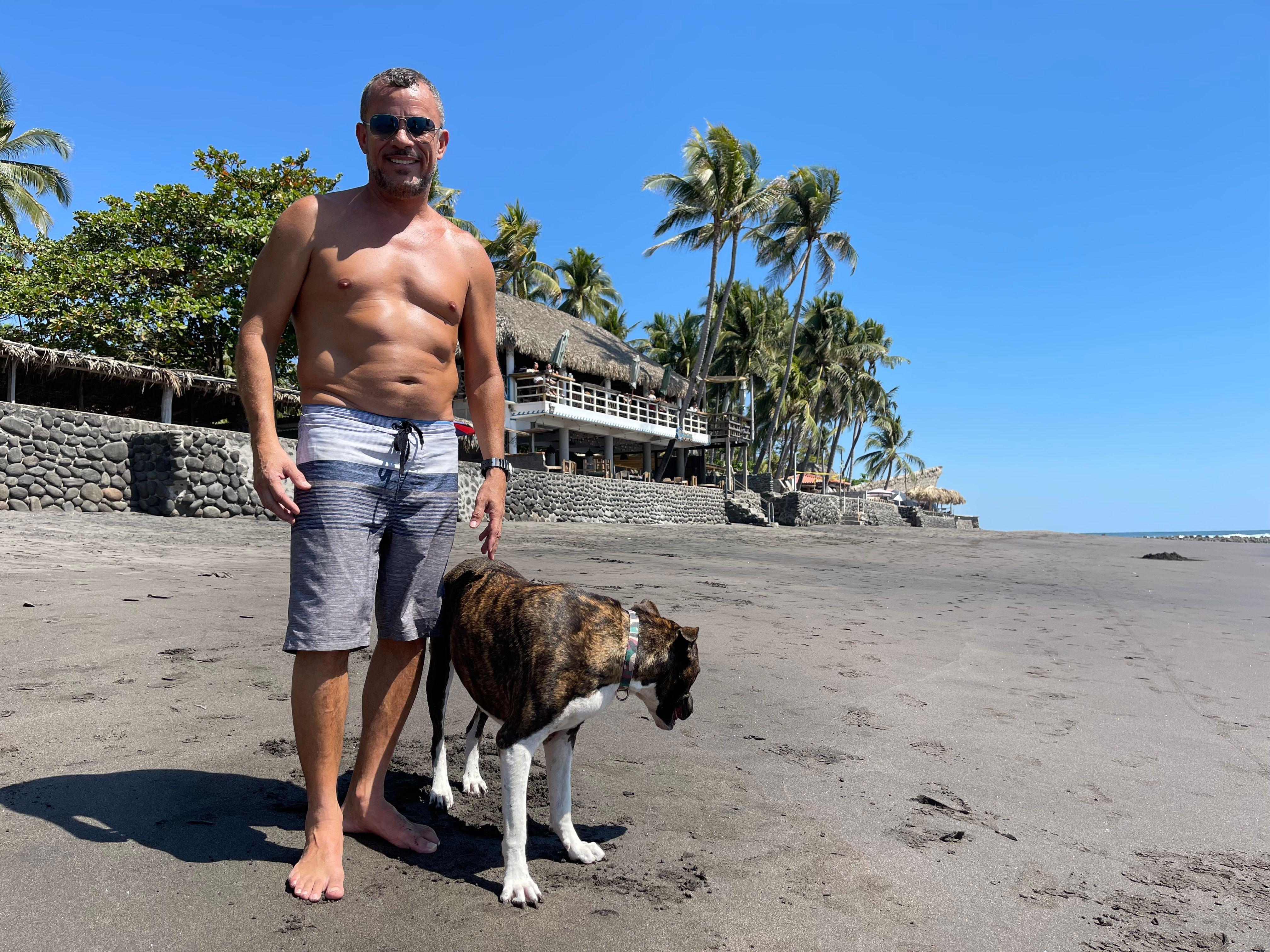 Carlos Enrique Novoa, dueño de Olas Permanentes (al fondo) en la playa El Zonte en El Salvador en febrero de 2024.