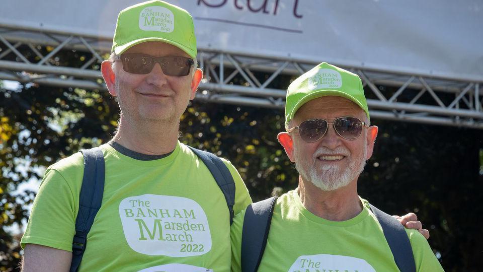 Dois homens com camisetas e bonés de beisebol combinando