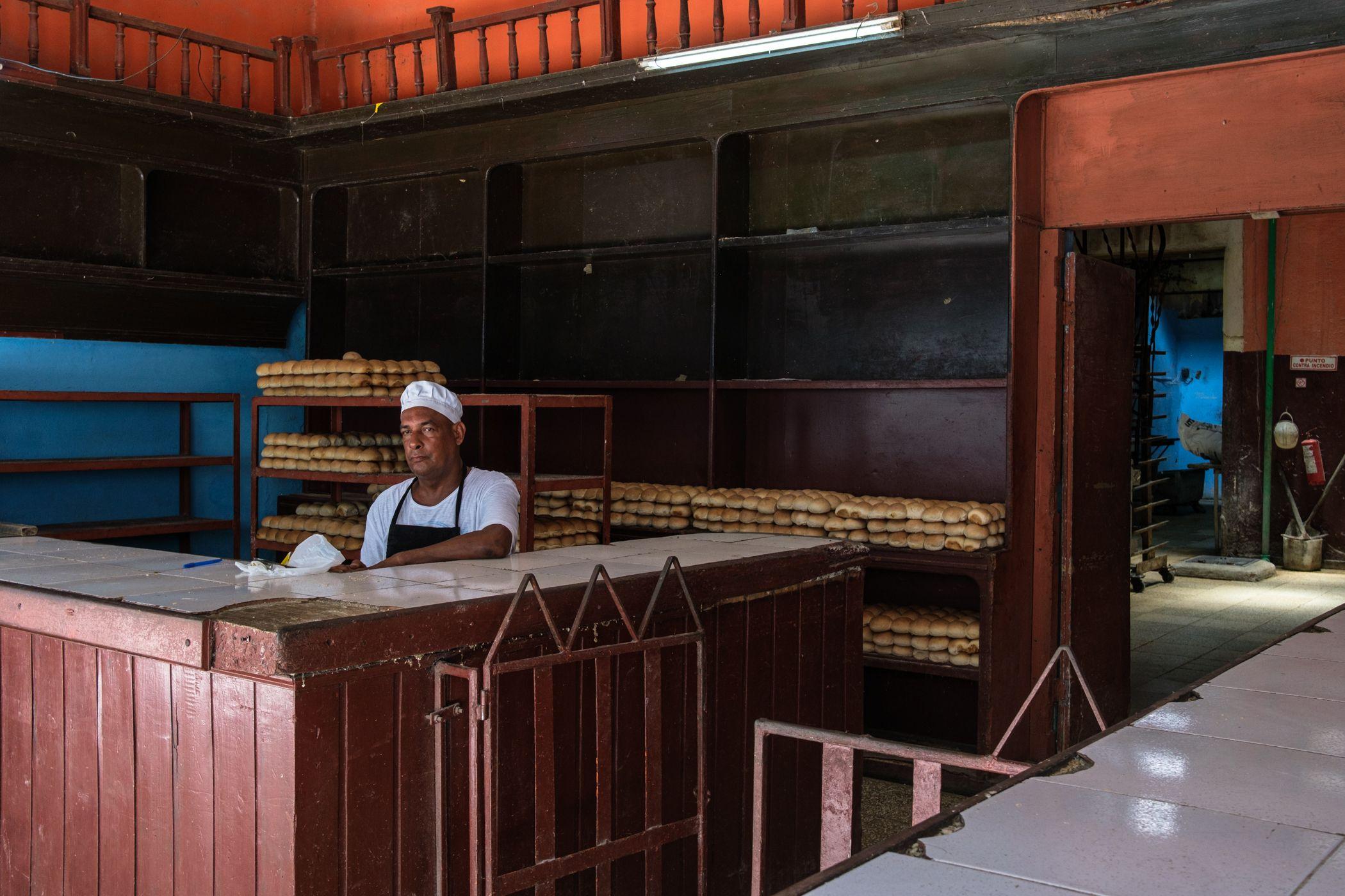 Panadero en una panadería en la que se ofrecen muy pocos productos. 