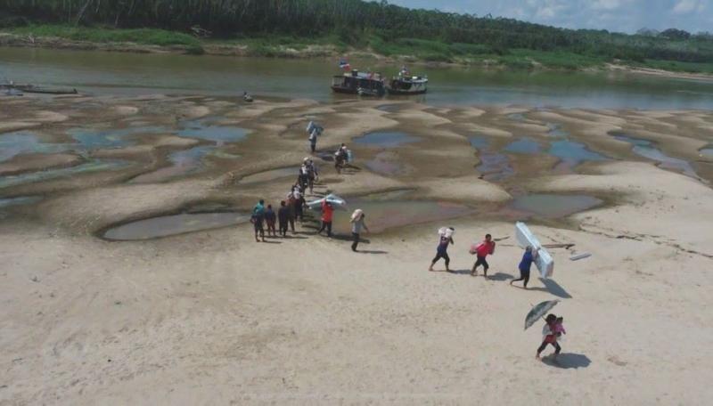 Pessoas caminham em leito seco de rio