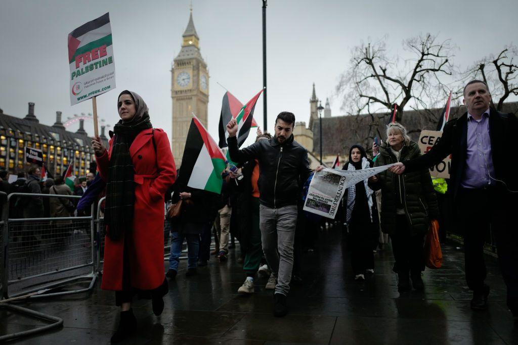متظاهرون يحملون أعلاماً ولافتات خلال مسيرة لدعم الشعب الفلسطيني في غزة، في ساحة البرلمان في لندن، في 21 فبراير/شباط 2024