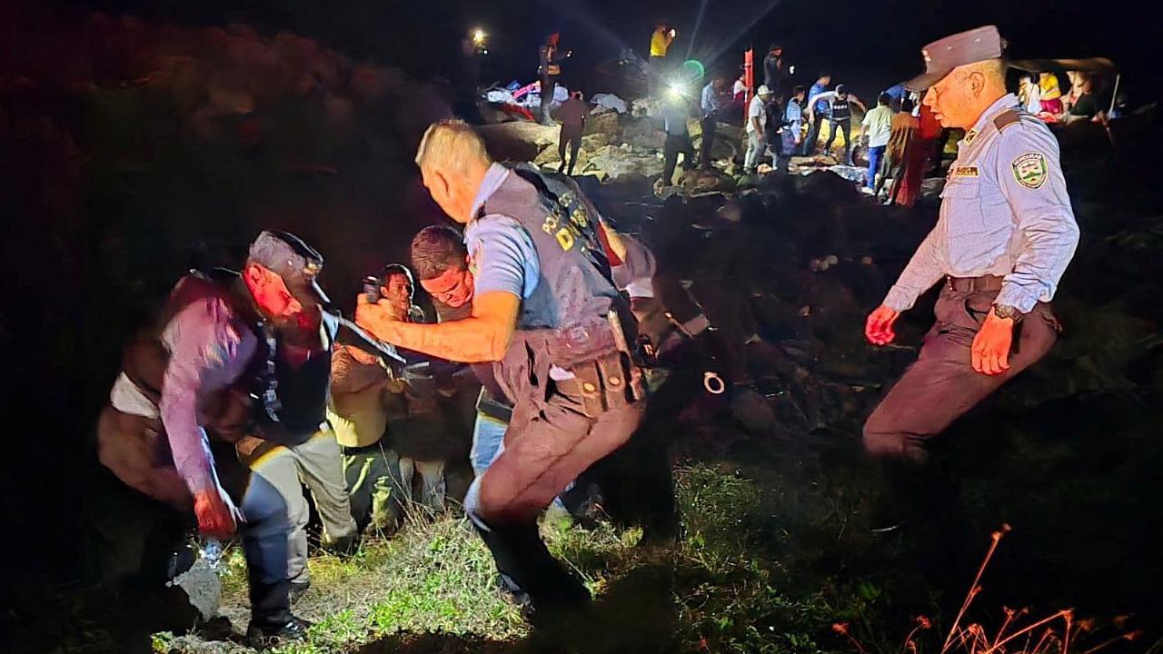 Policías trabajando en operaciones de rescate en la noche. 