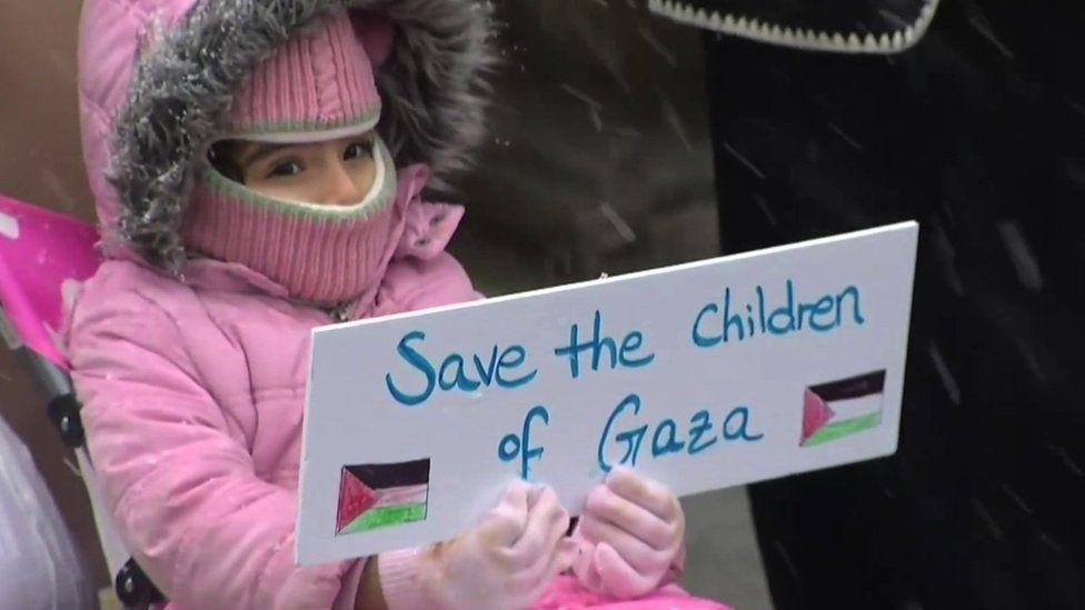 Una niña sostiene un cartel que lee: "Salven a los niños de Gaza", durante una manifestación