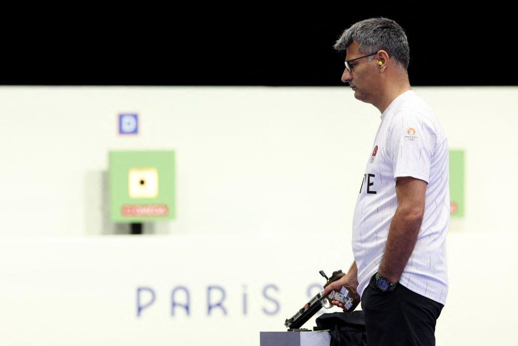 Yusuf Dikec, um homem branco de cabelos grisalhos, segurando uma pistola