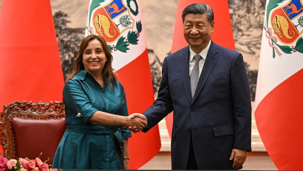 A presidente peruana, Dina Boluarte, e o presidente chinês, Xi Jinping, apertam as mãos em recente reunião em Pequim