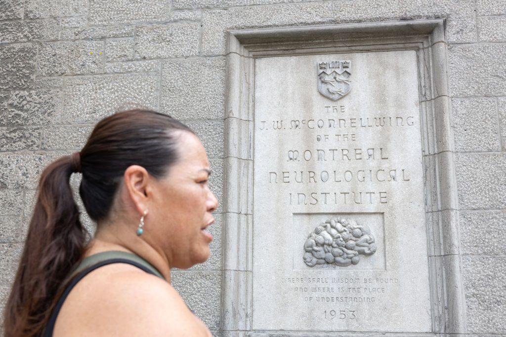 La Madre Mohawk Kwetiio pasa frente a la placa de dedicación del ala McConnell del Instituto-Hospital Neurológico de Montreal el 17 de julio de 2024, en Montreal, Canadá.
(Photo by Alexis Aubin / AFP) (Photo by ALEXIS AUBIN/AFP via Getty Images)