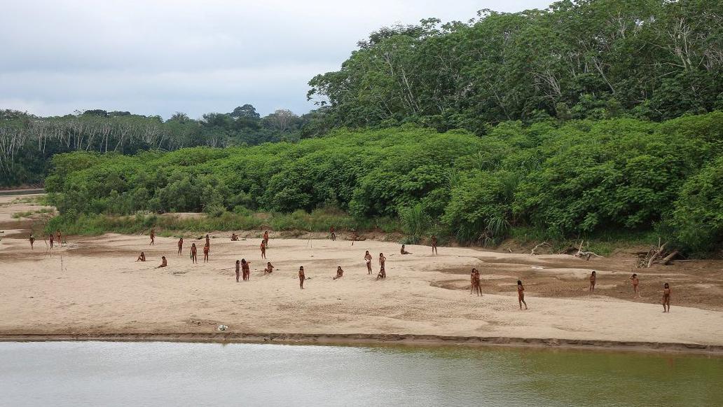 Grupo de indígenas isolados na beira de rio