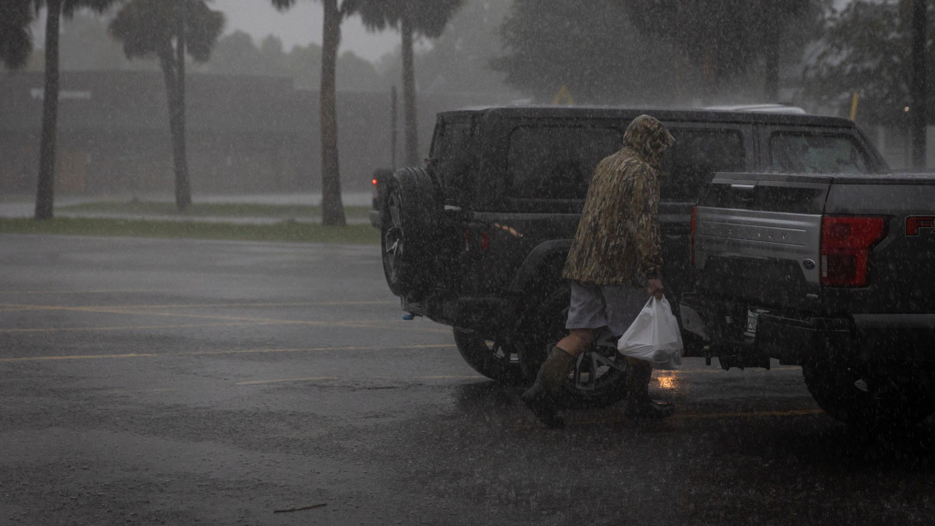 Um homem caminha na chuva com sacolas de mantimentos enquanto o furacão Helene se intensifica antes de sua esperada chegada em Big Bend, na Flórida, em Apalachicola, Flórida, EUA, 26 de setembro de 2024