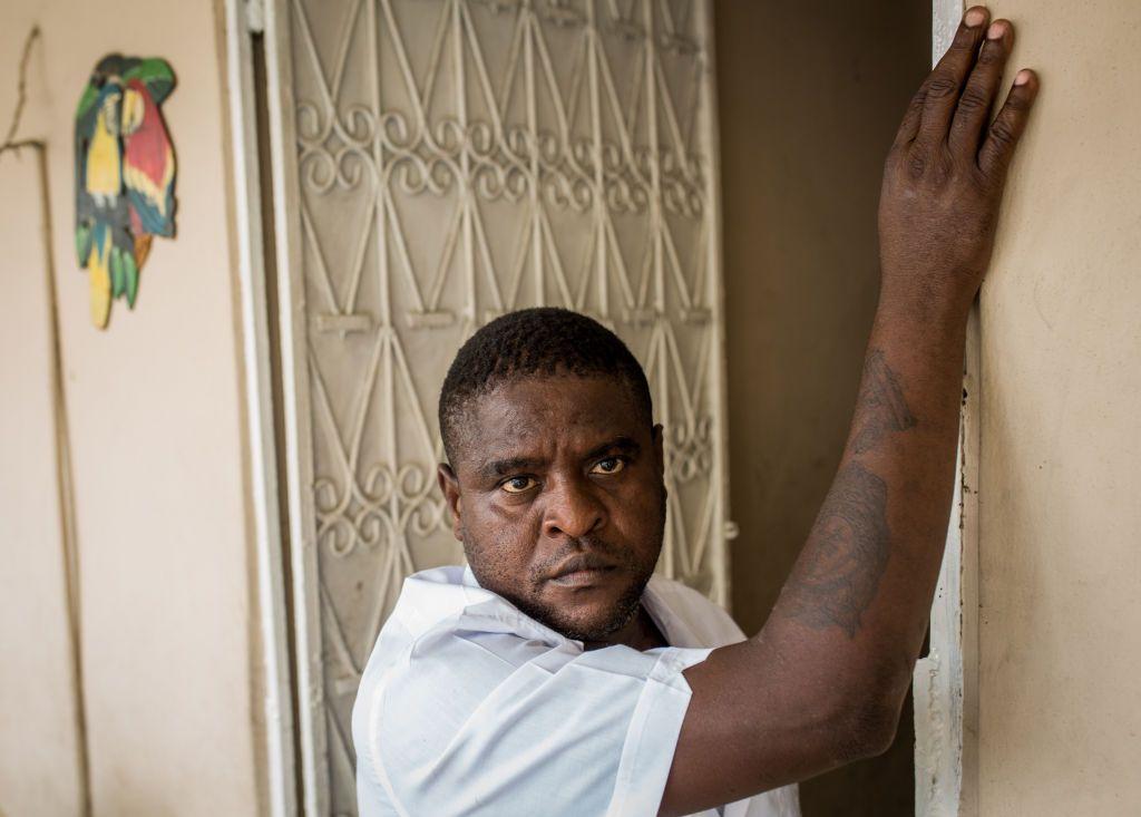 Jimmy Chérizier in a doorway, touching a wall