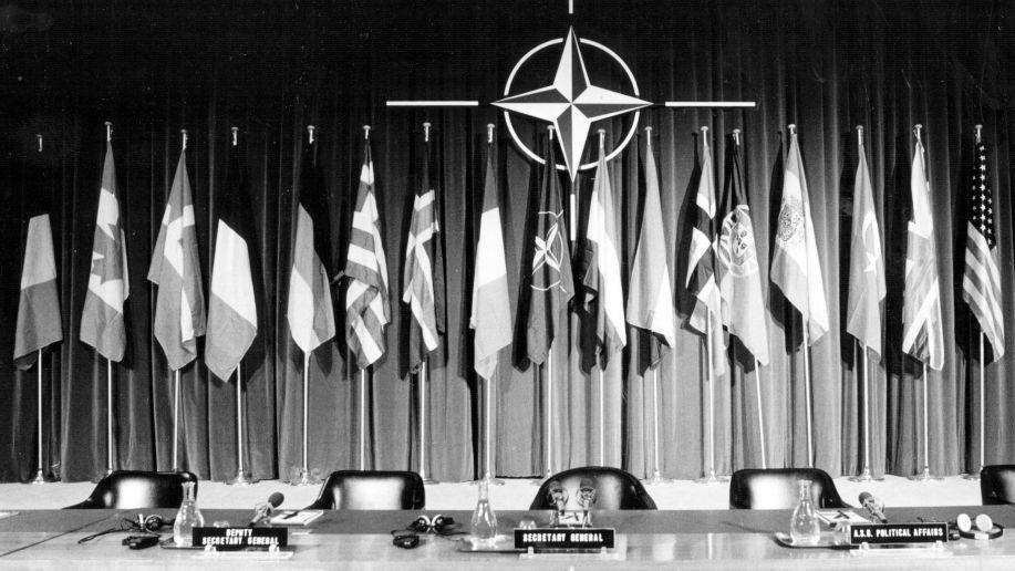 Uma mesa de conferência pronta para uma conferência de imprensa para Lord Carrington, o Secretário-Geral da OTAN em Bruxelas (12 de dezembro de 1984)
