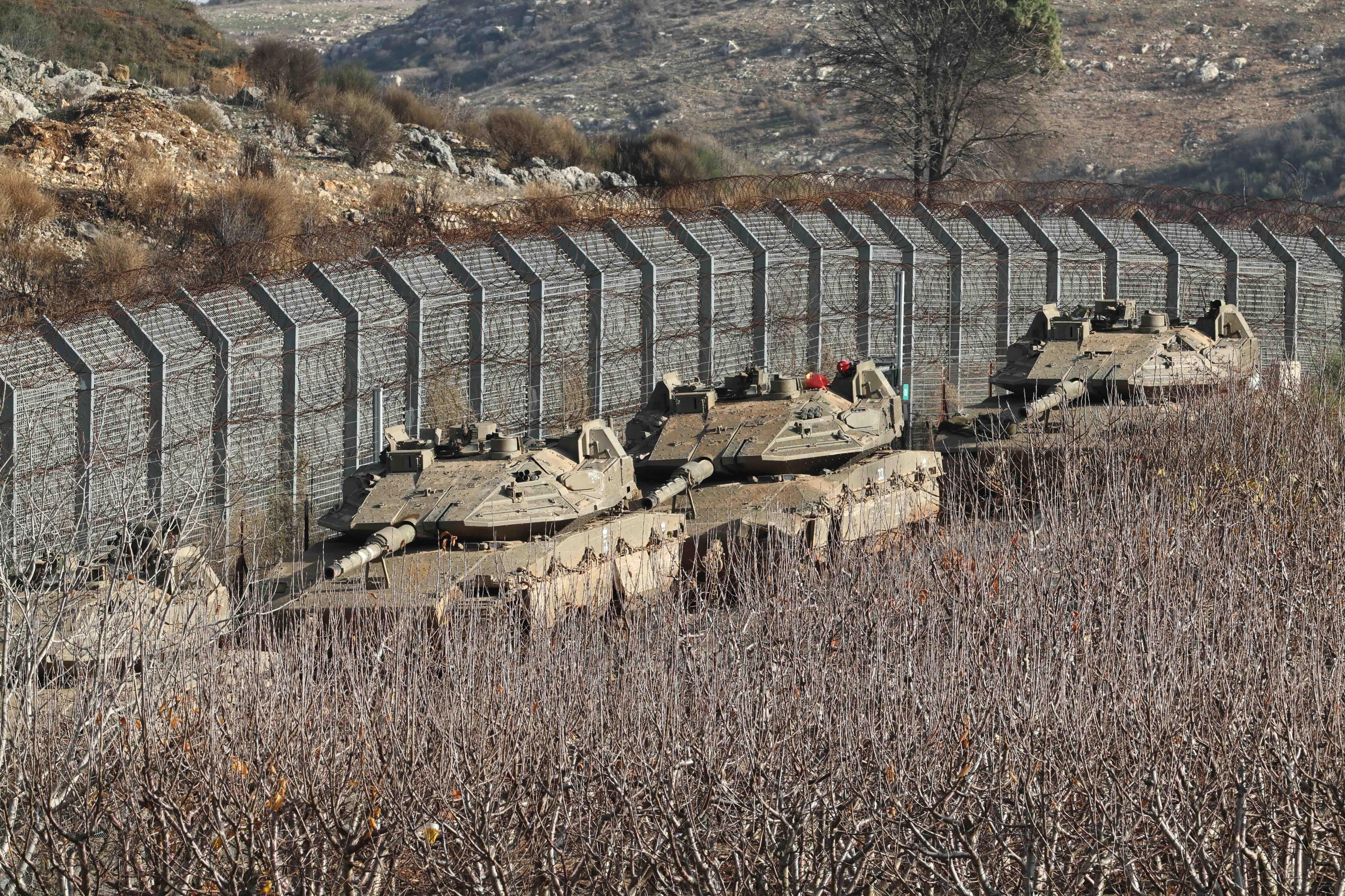 Tanques israelíes desplegados junto a la valla de seguridad cerca de la aldea drusa de Majdal Shams, en la frontera de Israel con Siria, en los Altos del Golán anexados por Israel.