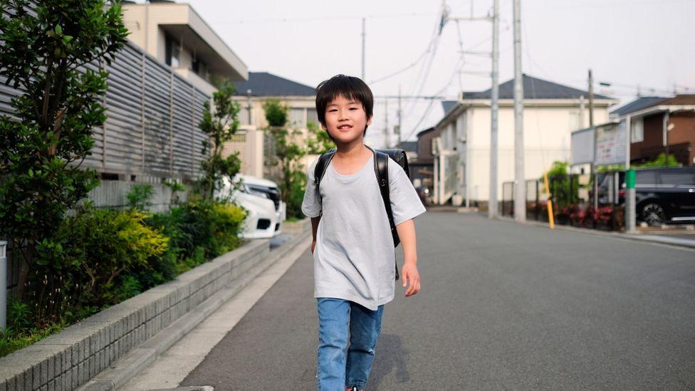 Menino andando sozinho na rua no Japão