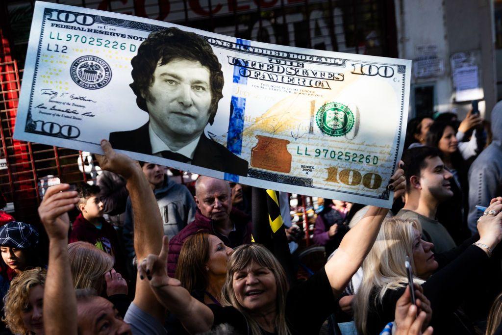 Manifestantes del candidato presidencial Javier Milei de La Libertad Avanza sostiene una réplica de un billete de cien dólares con la foto de Milei durante un mitin el 25 de septiembre de 2023 en San Martín, Buenos Aires, Argentina. (Foto de )