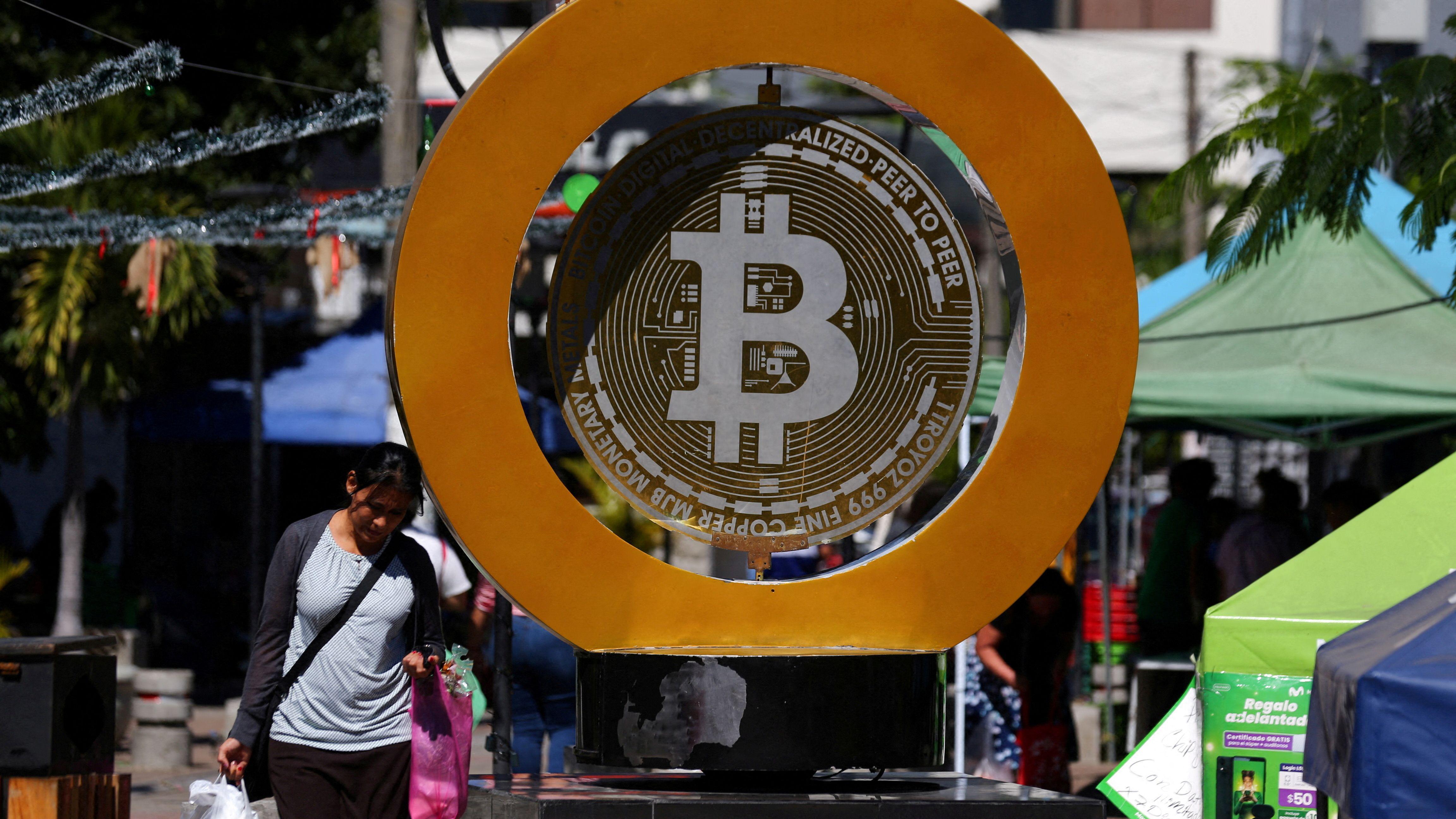 Una mujer pasa por el Monumento a Bitcoin después de que el bitcoin se disparara por encima de los 100.000 dólares, en Ilopango, El Salvador, el 5 de diciembre de 2024. REUTERS / José Cabezas 