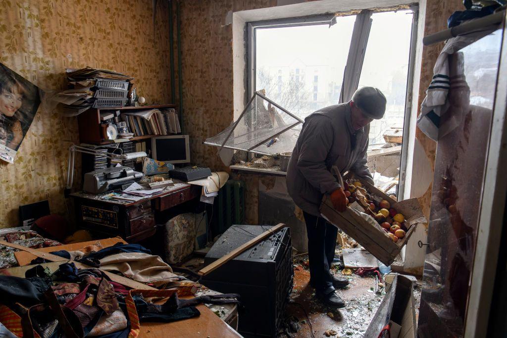 Un residente de Kyiv limpiando su apartamento gravemente afectado por un ataque ruso.