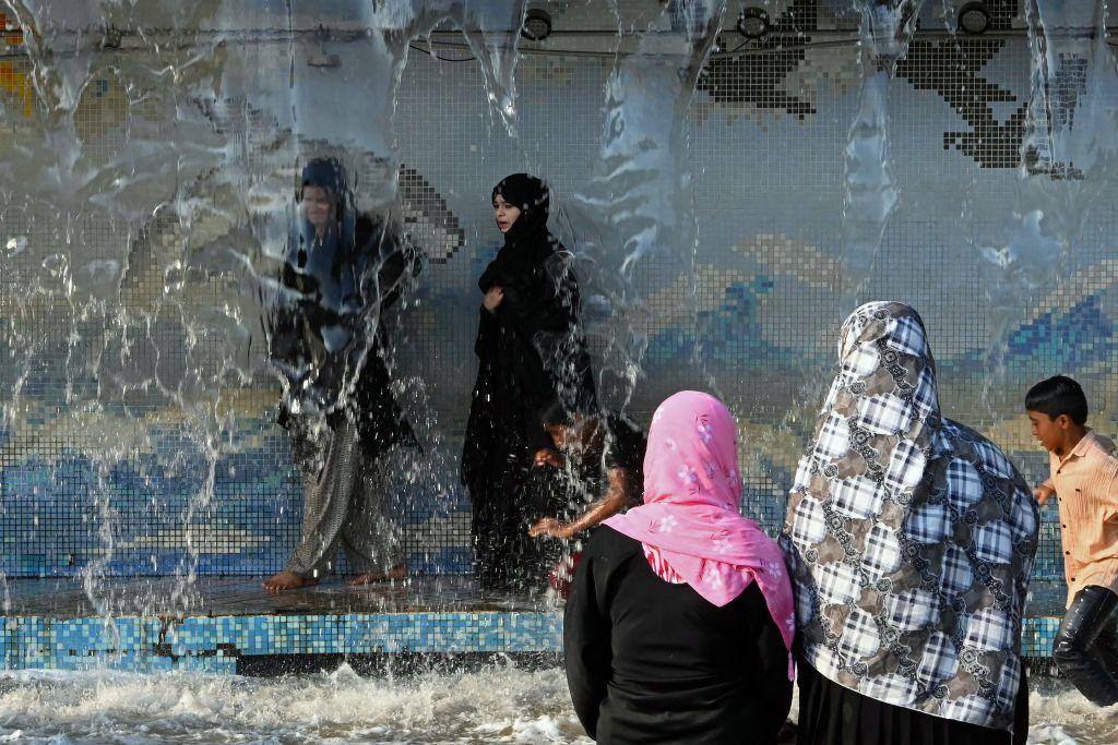 Unas mujeres se refugian del calor en una fuente 