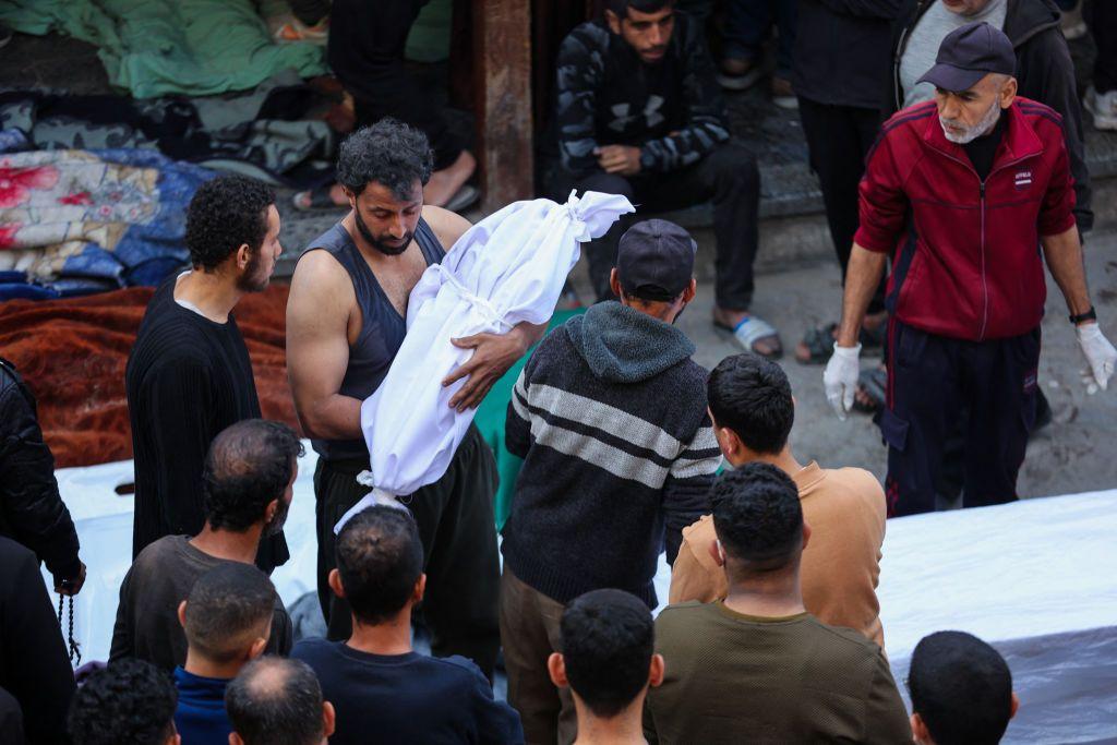 Un hombre carga el cadáver de un niño fallecido en el ataque aéreo de Israel sobre el hospital Al Mamdani de la ciudad de Gaza, en la Franja de Gaza, el 18 de marzo de 2025. (Foto: OMAR AL-QATTAA/AFP vía Getty Images)