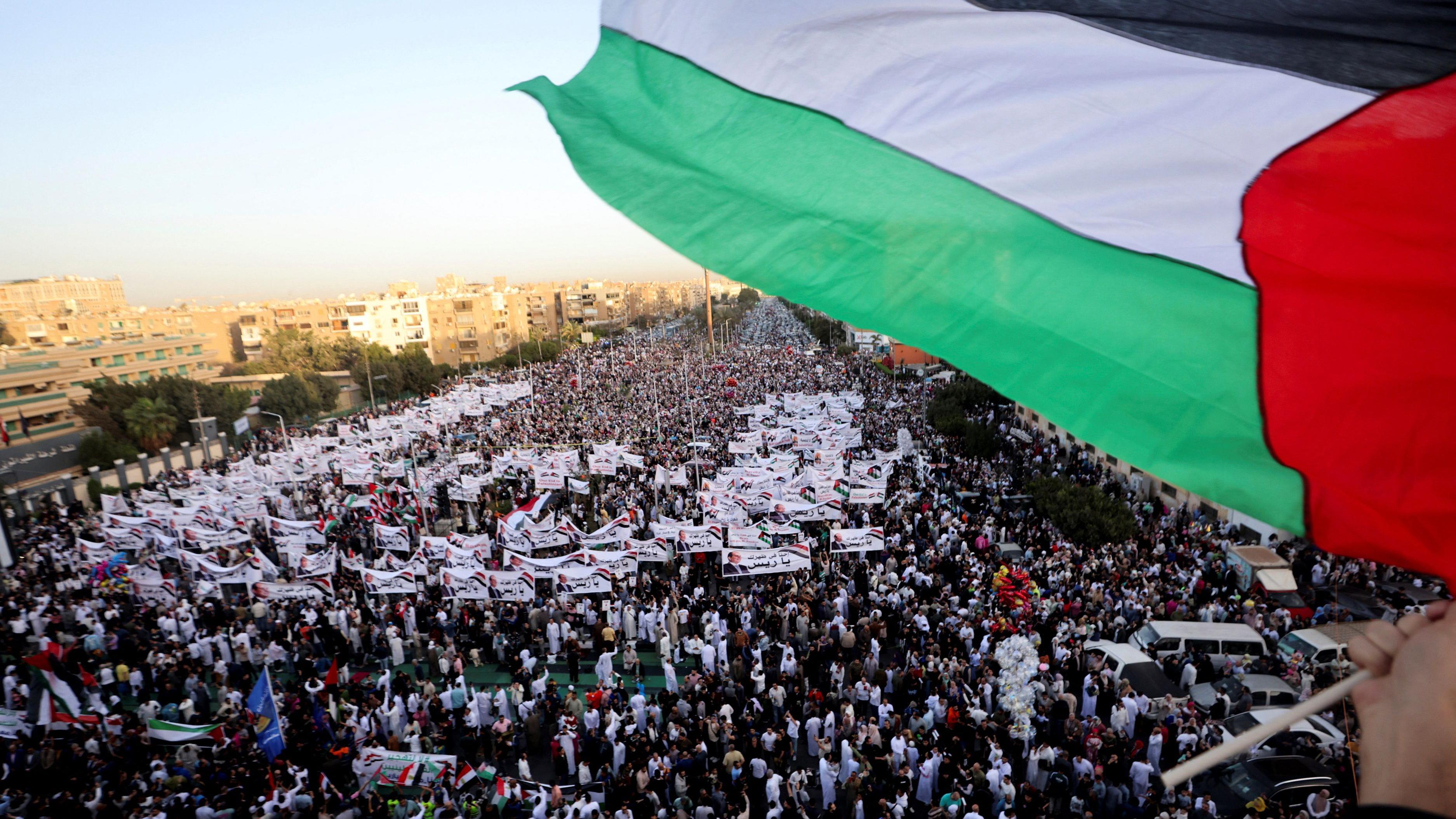 شخص يلوح بالعلم الفلسطيني أثناء مظاهرات في القاهرة رفضاً لتهجير الفلسطينيين