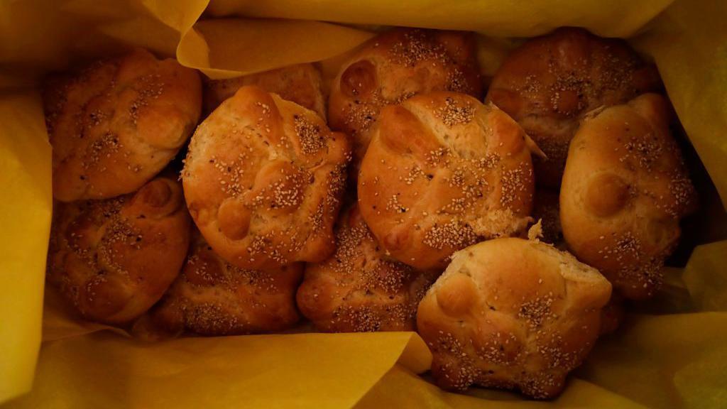 Una bolsa llena de bollitos de pan con semillas.