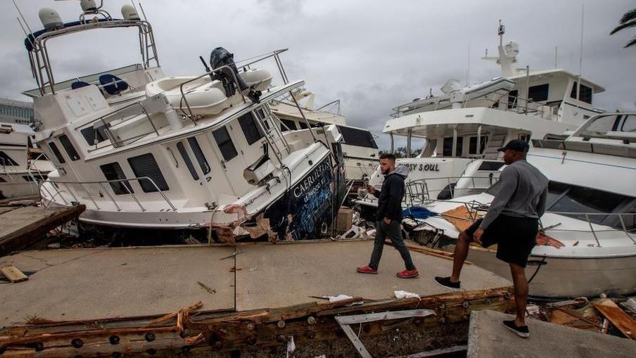Fort Myers'ta Ian Kasırgası'nın hasar verdiği tekneleri inceleyenler. 