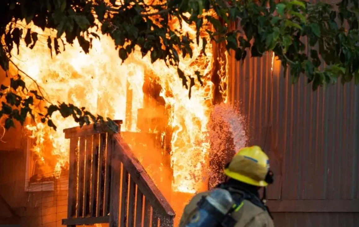 Bombeiro espalha água em imóvel incendiado