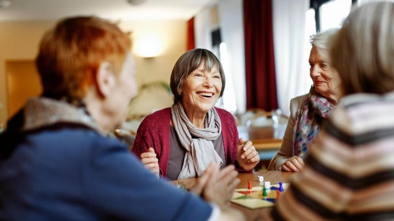 idosas sorrindo em mesa com jogo de tabuleiro