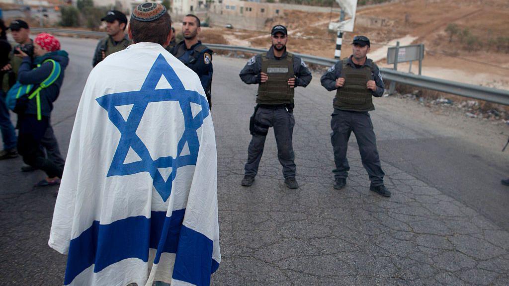 Um colono israelense enfrenta policiais israelenses em uma manifestação na entrada da vila de Beit Sahur, na Cisjordânia