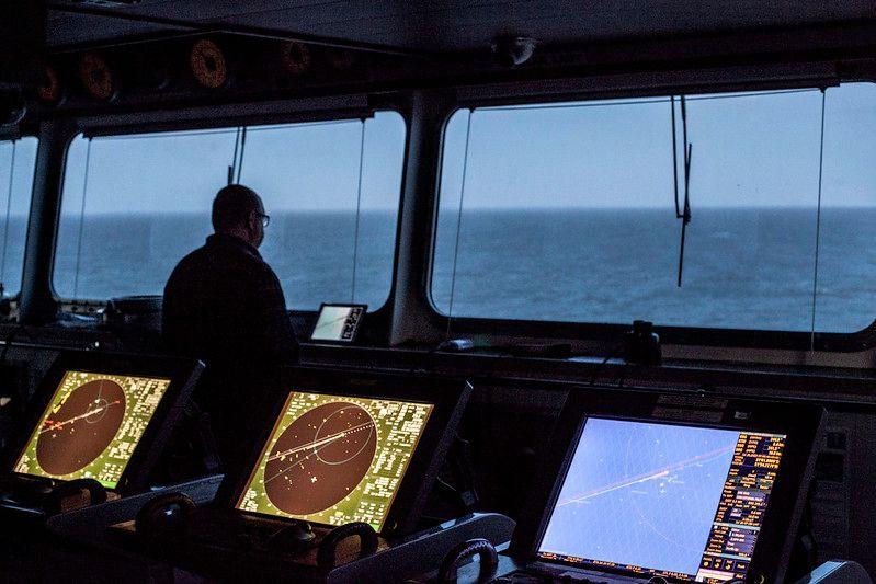 Sombra de homem olhando para mar de dentro de navio