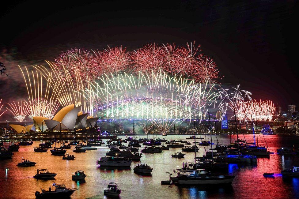 La Ópera y el Puente del Puerto de Sídney iluminados con fuegos artificiales de diferentes colores