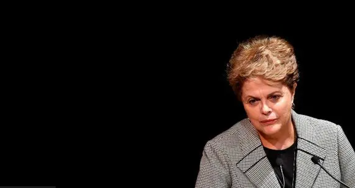 Dilma Rousseff em frente a um microfone