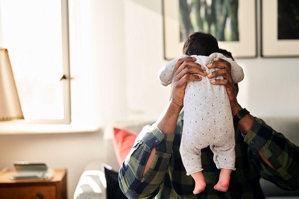 A man holds up a baby