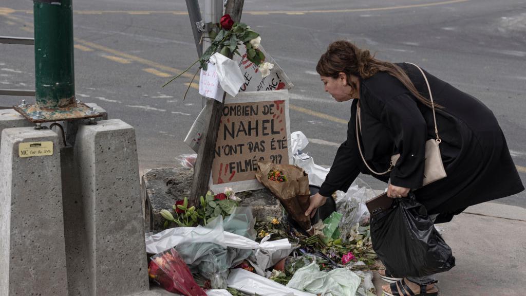 Una mujer presenta sus respetos en el lugar donde murió Nahel M., poco después de su funeral, el 1 de julio de 2023 en Nanterre.