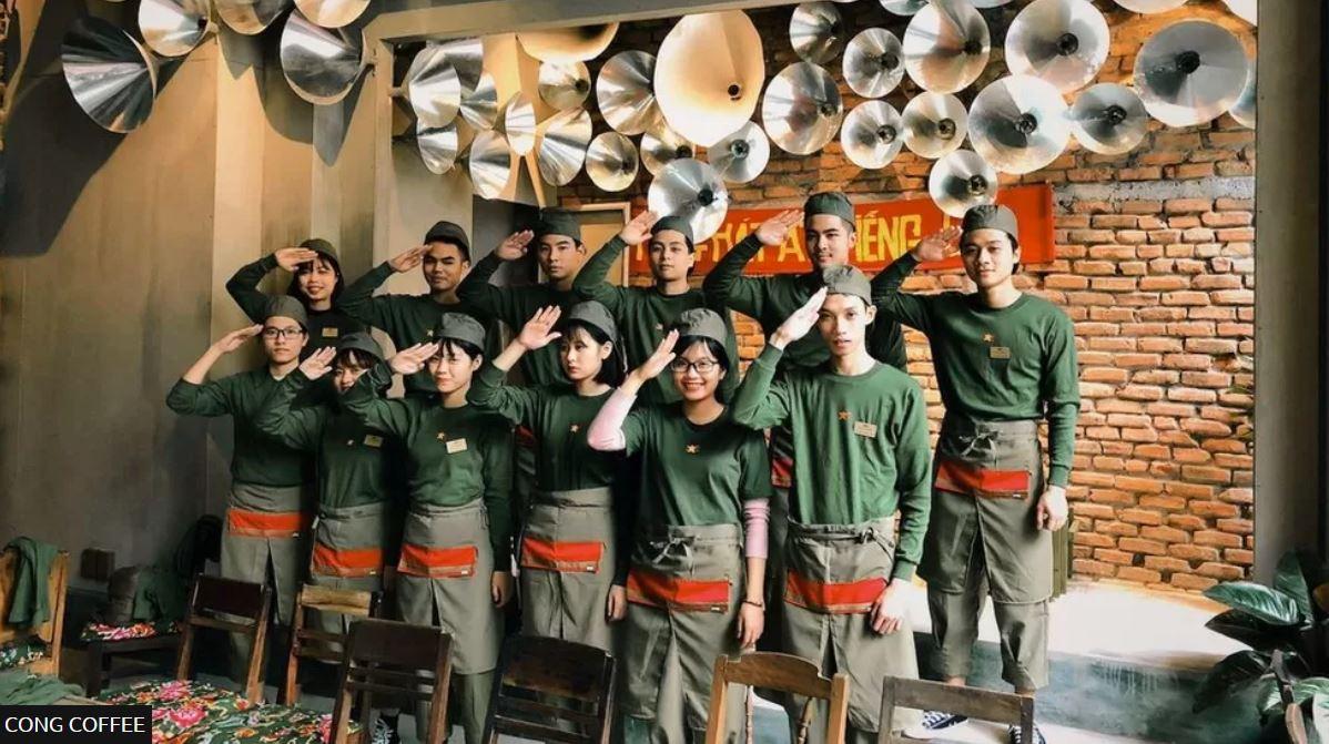 مجموعة من الموظفين في مقهى مونغ كوفي الفيتنامي يؤدون تحية ذات طابع عسكري