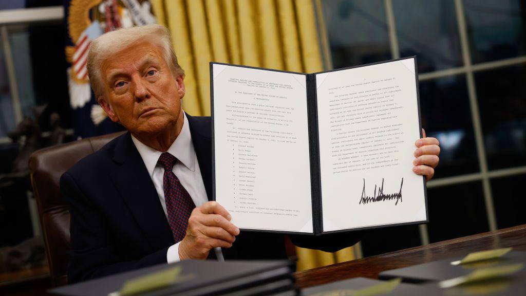 Donald Trump muestra una orden ejecutiva firmada