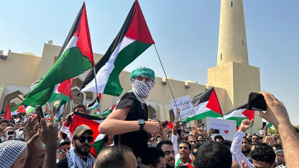 متظاهرون يرفعون العلم الفلسطيني في قطر