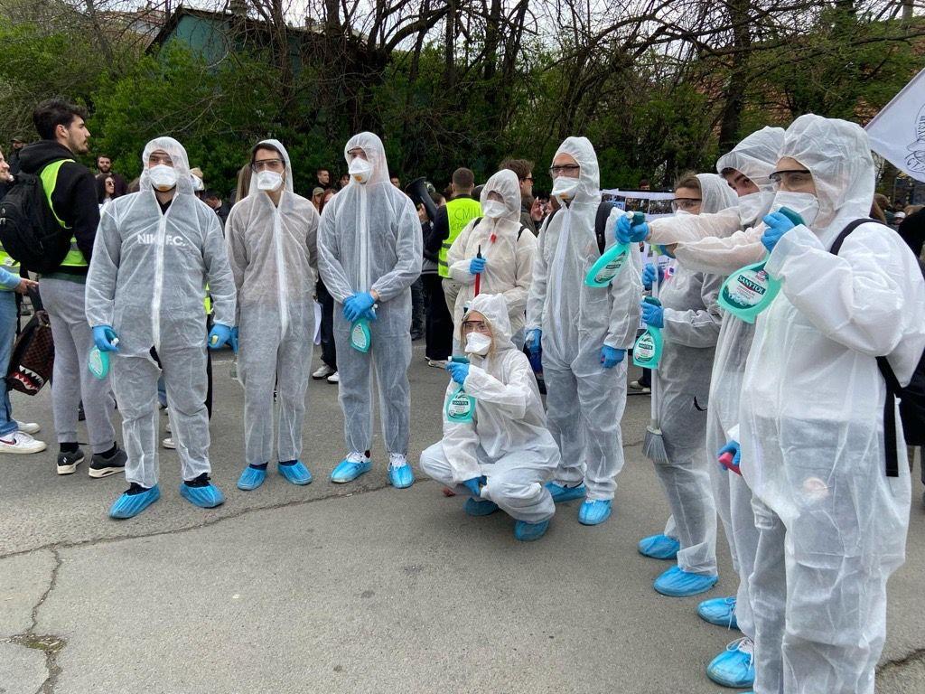 Studenti u zaštitnim hirurškim odelima na protestu isrped televizije Informer