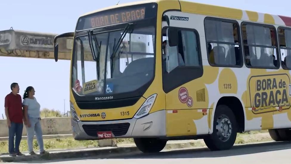 Duas pessoas no ponto e ônibus gratuito em Caucaia, no Ceará