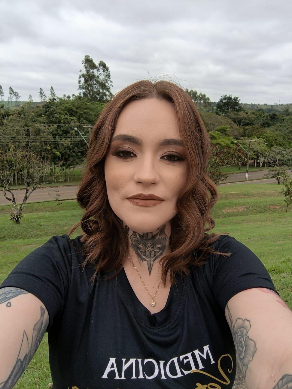 Carolina maquiada fazendo selfie em parque