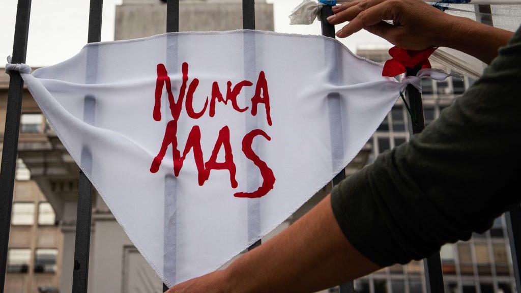 Un pañuelo blanco -símbolo de las Madres de Plaza de Mayo- con el lema "Nunca Más".