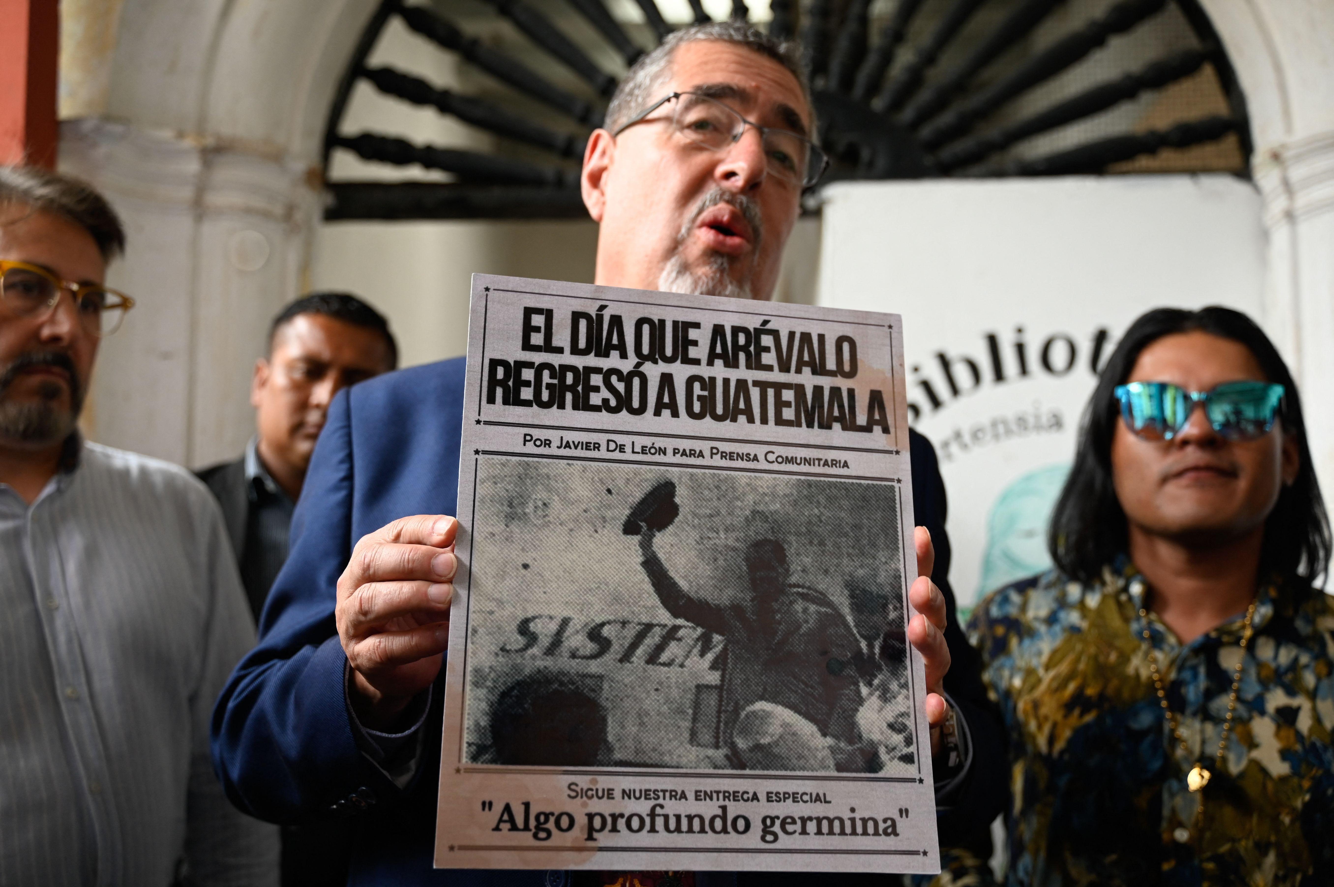 Bernardo Arévalo muestra la portada de un períodico con su padre, el expresidente Juan José Arévalo, regresando a Guatemala tras su exilio.