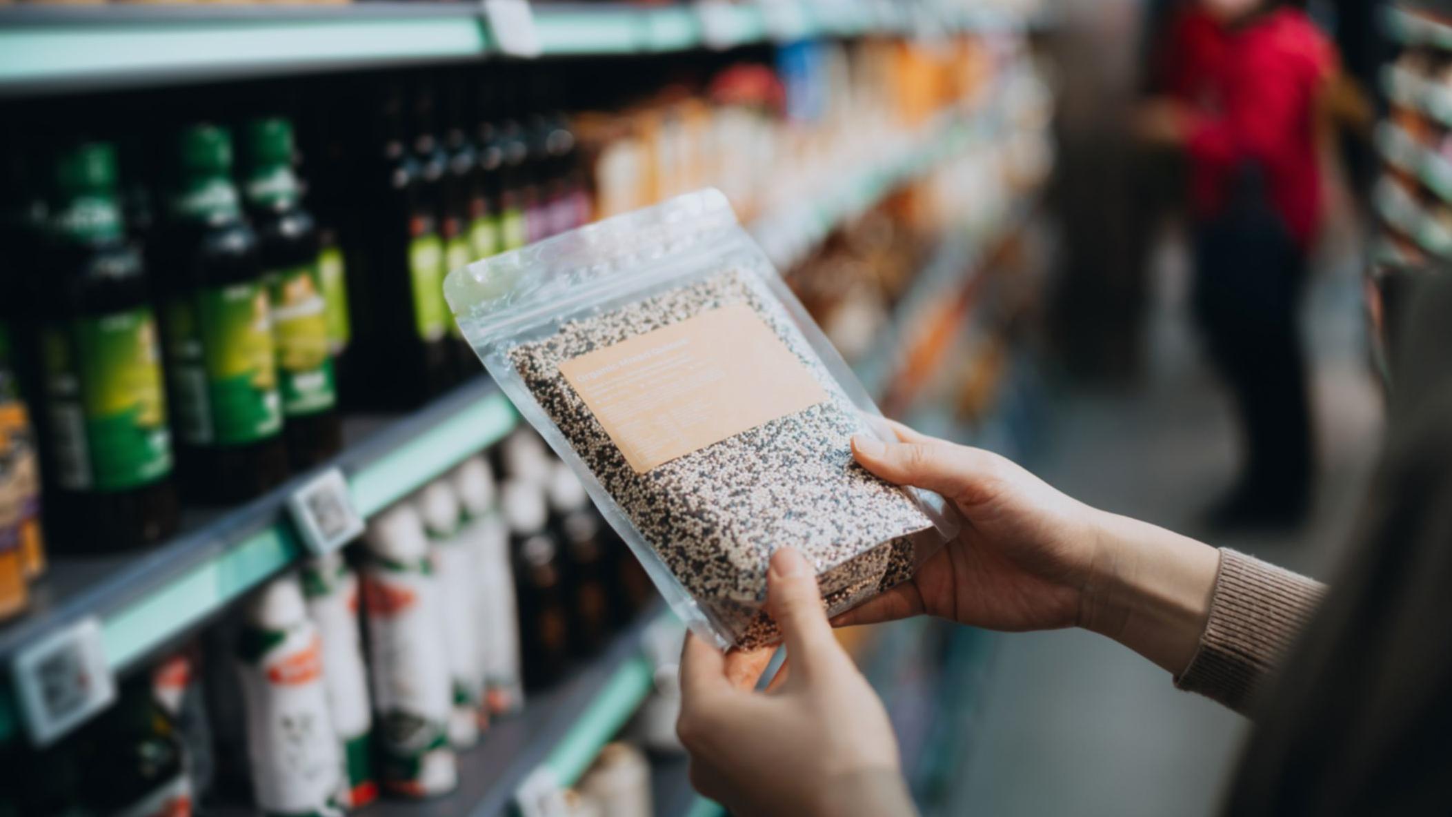 Una persona sostiene un producto etiquetado como natural en un supermercado