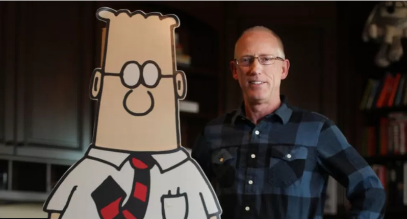 Scott Adams ao lado de uma ilustração de Dilbert