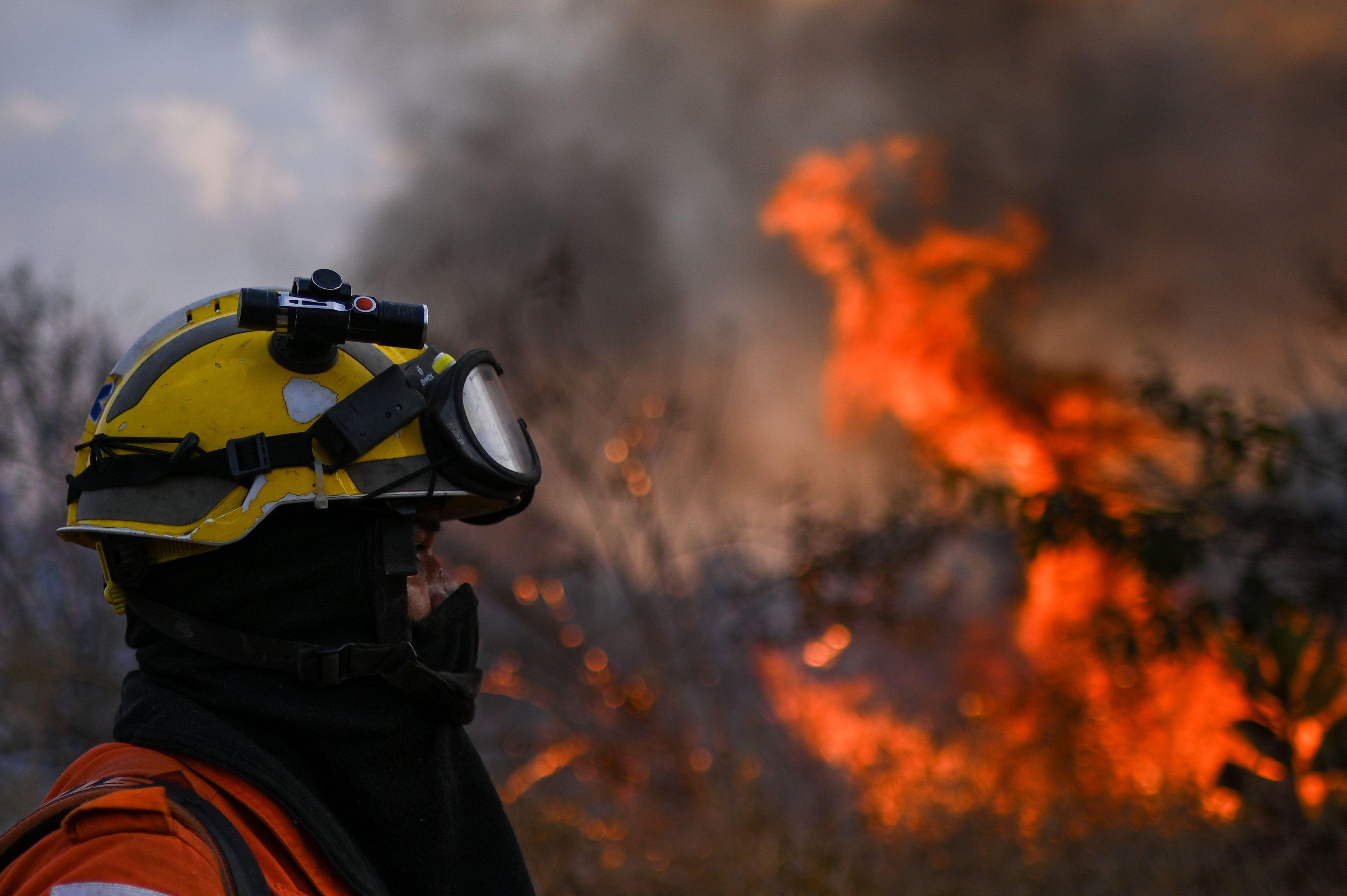 Um bombeiro do Instituto Ambiental de Brasília (IBRAM) trabalha para apagar um incêndio florestal no Parque Ecológico Burle Marx, em Brasília, Brasil, 27 de agosto de 2024. 