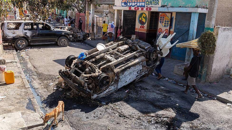 Calle en Puerto Príncipe bloqueada por autos volcados e incendiados