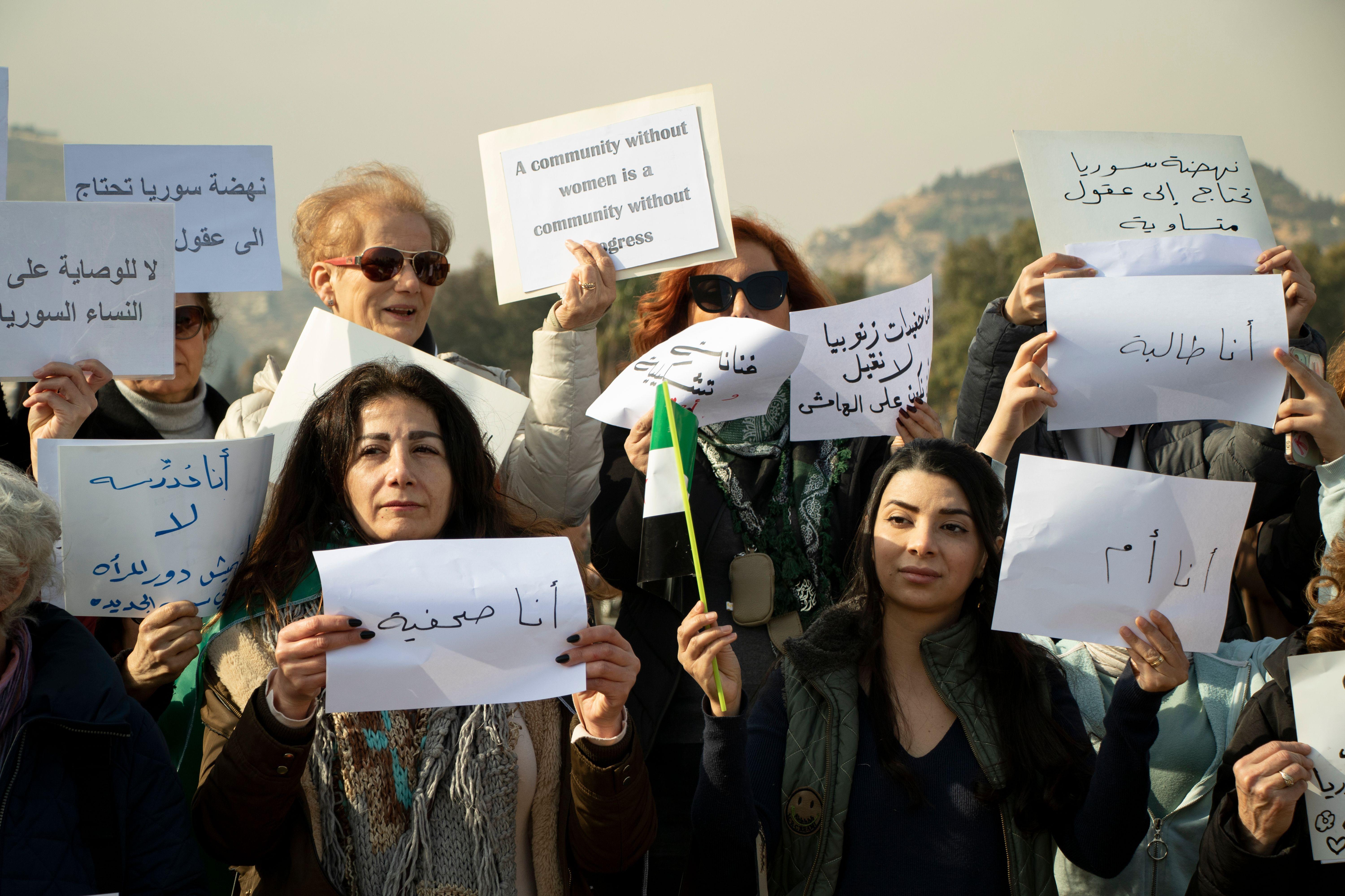 نساء سوريات يرددن شعارات ويحملن لافتات خلال احتجاج في دمشق بعد سقوط حكم الأسد