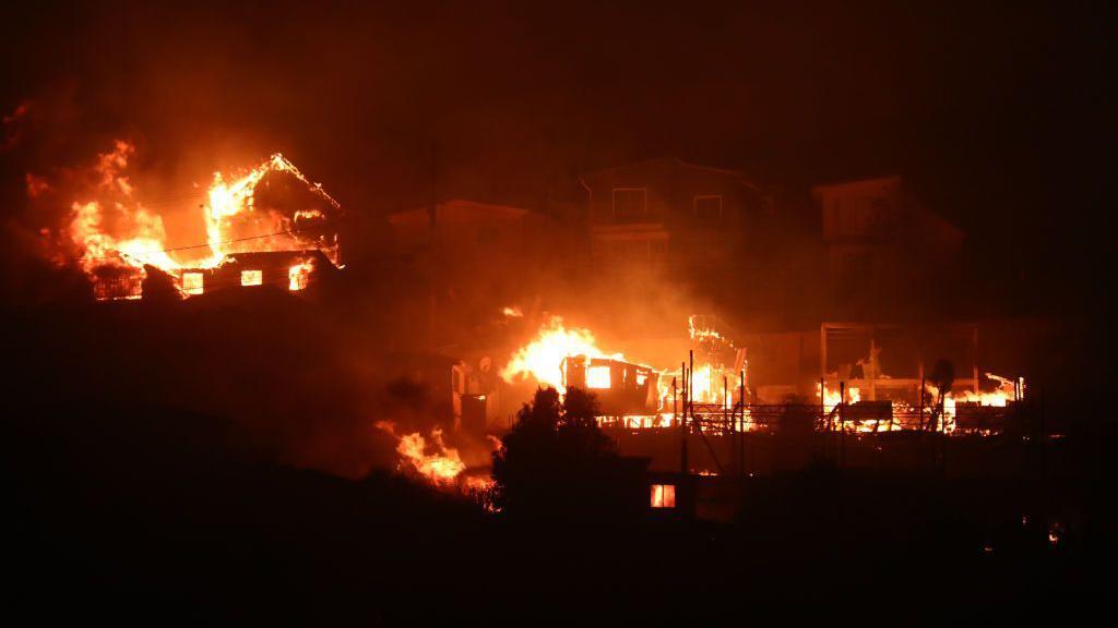 Casas arden debido a un incendio forestal durante la noche en Valparaíso, Chile el 2 de febrero de 2024. 