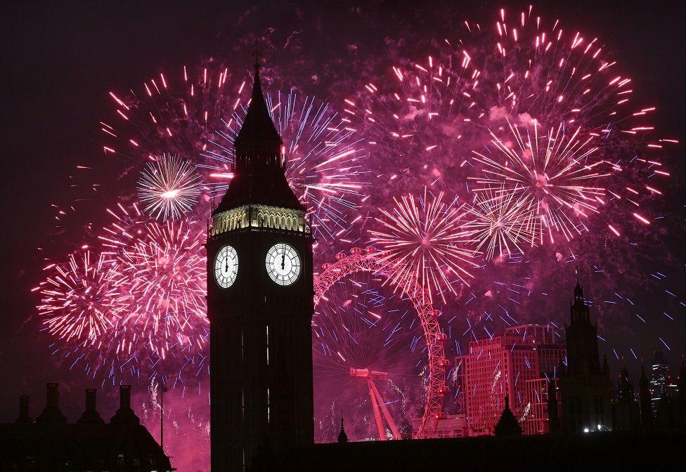 Fuegos artificales rosados iluminando el Big Ben y el London Eye