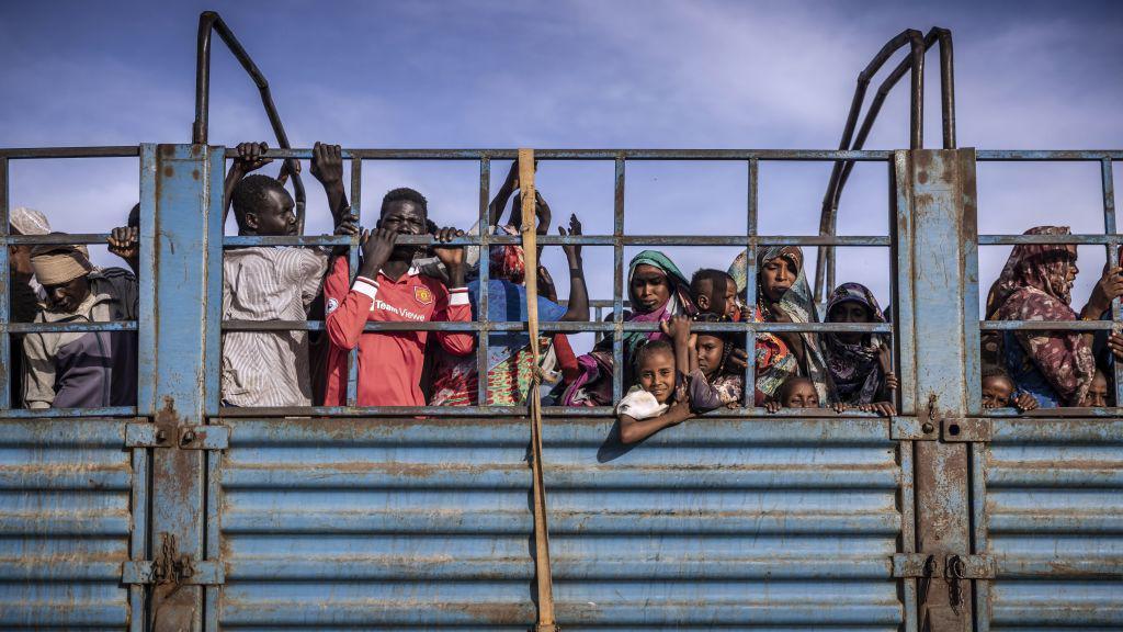 sudaneses en una camioneta descapotada 